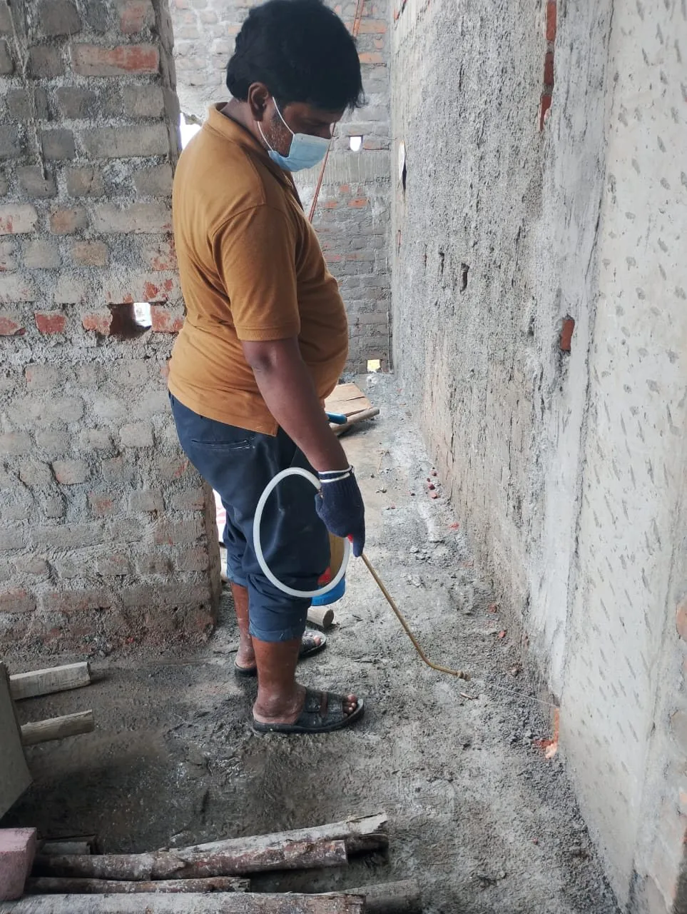 Technician treating a building under construction for termites